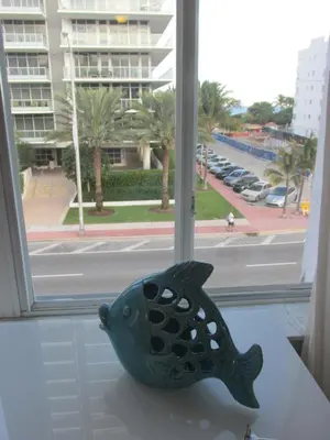 a fish statue sitting on a table in front of a window at Ocean Breeze in Miami Beach