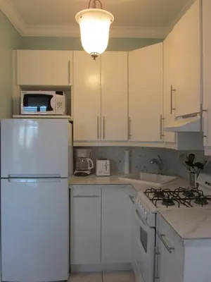 a kitchen with white cabinets and a white refrigerator at Ocean Breeze in Miami Beach