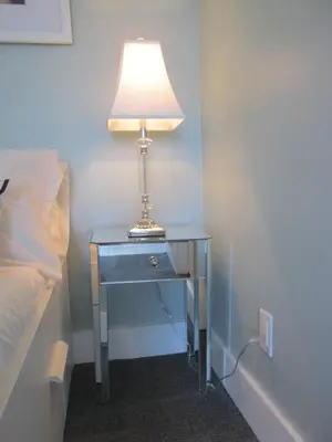 a table with a lamp on it next to a bed at Ocean Breeze in Miami Beach