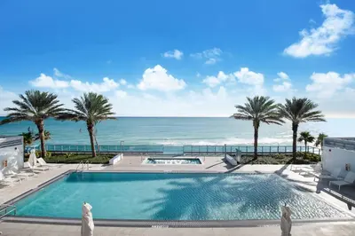 a swimming pool with a view of the ocean at Global Luxury Suites at Monte Carlo in Miami Beach