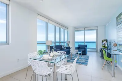 a living room with a glass table and chairs at Global Luxury Suites at Monte Carlo in Miami Beach