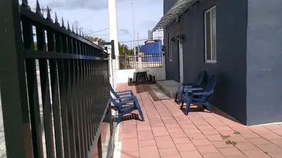 two blue chairs sitting on a patio next to a fence at Fatimataj Mahal in Miami