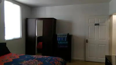 a bedroom with a bed and a closet and a door at Fatimataj Mahal in Miami
