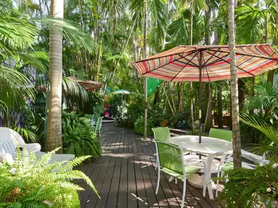 a patio with a table and chairs and an umbrella at Pineapple Point Guesthouse & Resort - Gay Men's Resort in Fort Lauderdale