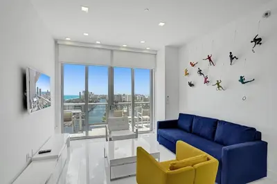 a living room with a blue couch and a yellow chair at Modern Penthouse condo with 2 Large private terraces in Hollywood