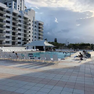 a swimming pool with chairs and a building at Ocean Front Studio Units in Miami Beach