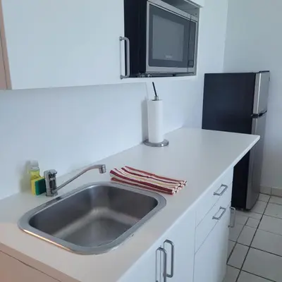 a kitchen counter with a sink and a microwave at Ocean Front Studio Units in Miami Beach