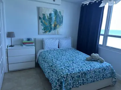 a bedroom with a bed with a teddy bear on it at Ocean Front Studio Units in Miami Beach