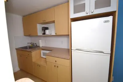 a small kitchen with a white refrigerator in it at Ocean Front Studio Units in Miami Beach