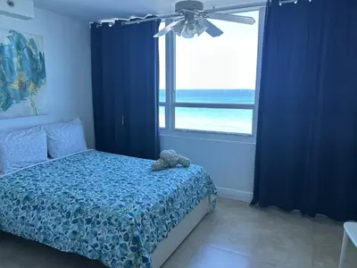 a bedroom with a bed with a teddy bear on it at Ocean Front Studio Units in Miami Beach