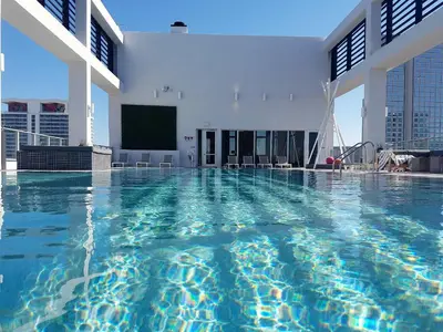 a large swimming pool in a building with a screen at Downtown Miami Deluxe Apartment in Miami