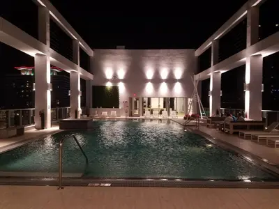 a swimming pool in the middle of a building at night at Downtown Miami Deluxe Apartment in Miami