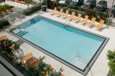 an overhead view of a large swimming pool with lounge chairs at Aloft Miami Airport in Miami