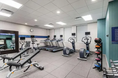 a gym with rows of treadmills and cardio machines at Hampton Inn & Suites Miami Wynwood Design District, FL in Miami