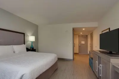 a hotel room with a bed and a flat screen tv at Hampton Inn & Suites Miami Wynwood Design District, FL in Miami