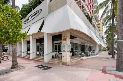 a building with a white awning on a street at Beachfront Bentley Hotel One Bedroom Suite with Balcony and Beach access in Miami Beach