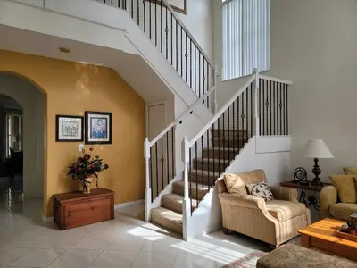 a living room with a staircase and a couch at My Florida Lake House in Homestead