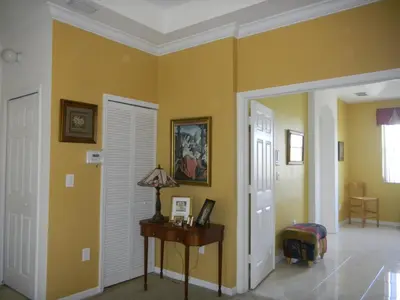 a room with yellow walls and a table with a lamp at My Florida Lake House in Homestead