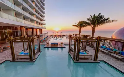 a pool at a hotel with a view of the ocean at Luxury Beach Resort in Hollywood