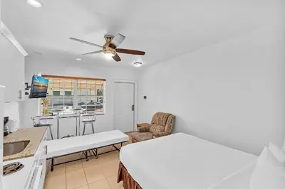 a white room with a bed and a kitchen at The Sunrise in Hollywood