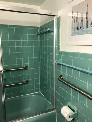 a green tiled bathroom with a shower and a tub at May-Dee Suites in Florida in Hollywood