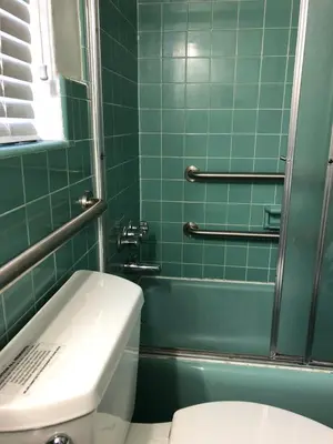 a green tiled bathroom with a toilet and a shower at May-Dee Suites in Florida in Hollywood