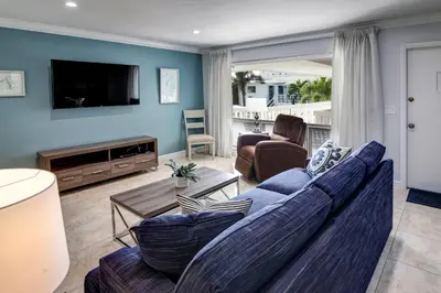 a living room with a couch and a tv at May-Dee Suites in Florida in Hollywood