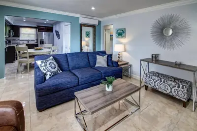 a living room with a blue couch and a table at May-Dee Suites in Florida in Hollywood