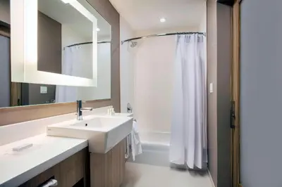 a white bathroom with a sink and a shower at SpringHill Suites by Marriott Miami Doral in Miami