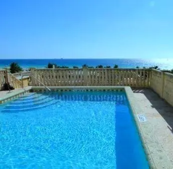 a large blue swimming pool next to a wooden fence at The Fritz Hotel in Miami Beach