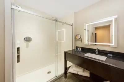 a bathroom with a shower and a sink and a mirror at Wingate by Wyndham Miami Airport in Miami