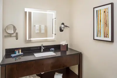 a bathroom with a sink and a mirror at Wingate by Wyndham Miami Airport in Miami