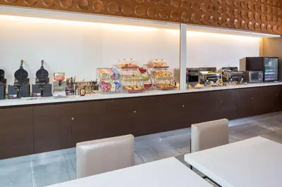 a restaurant with a counter with food on it at Wingate by Wyndham Miami Airport in Miami