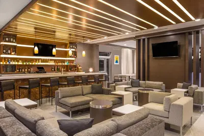 a hotel lobby with couches and a bar at Wingate by Wyndham Miami Airport in Miami