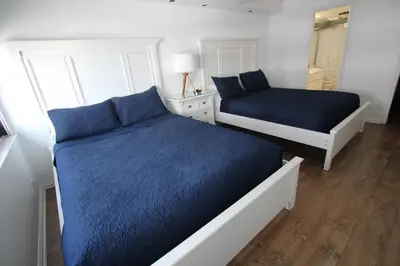 a bedroom with two beds with blue sheets at 2 Bedroom 2 Bath Beachfront Condo on Miami Beach Millionaire Row in Miami Beach