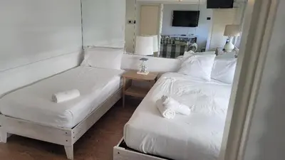 a bedroom with two beds and a table with a mirror at 2 Bedroom 2 Bath Beachfront Condo on Miami Beach Millionaire Row in Miami Beach