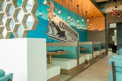 a waiting room with blue walls and white chairs at Four Points by Sheraton Miami Airport in Miami