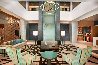 a lobby with couches and a table and chairs at Four Points by Sheraton Miami Airport in Miami