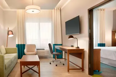 a hotel room with a desk and a bed and a room at Four Points by Sheraton Miami Airport in Miami