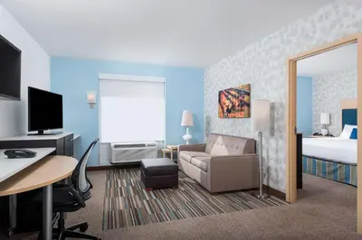a hotel room with a bed and a couch and a desk at Home2 Suites By Hilton Ft. Lauderdale Airport-Cruise Port in Dania Beach