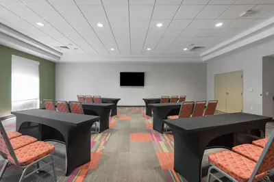 a conference room with tables and chairs and a tv at Home2 Suites By Hilton Ft. Lauderdale Airport-Cruise Port in Dania Beach