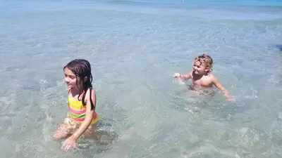 two children playing in the water at the beach at On The Beach - Lux 2 Bedroom Miami in Hollywood