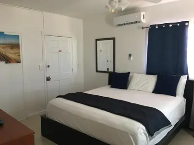 a bedroom with a large bed with blue curtains at Golden Sand Oceanfront in Hollywood