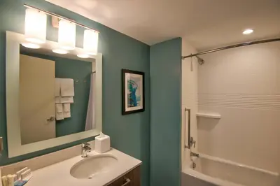 a bathroom with a sink and a shower and a mirror at TownePlace Suites by Marriott Miami Airport in Miami