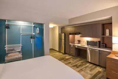 a hotel room with a bed and a kitchen at TownePlace Suites by Marriott Miami Airport in Miami