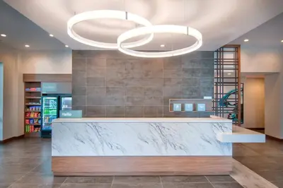 a lobby with a marble counter and two chandeliers at TownePlace Suites by Marriott Miami Airport in Miami