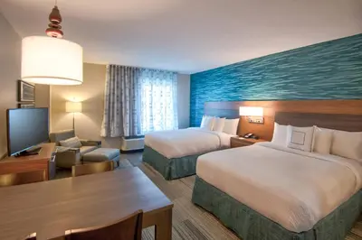 a hotel room with two beds and a desk at TownePlace Suites by Marriott Miami Airport in Miami