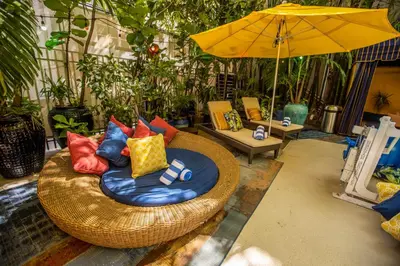 a wicker chair with colorful pillows and an umbrella at Riviera Suites in Miami Beach