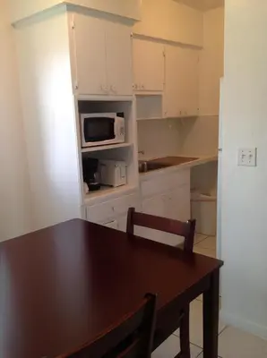 a kitchen with a table and a microwave at Summerland Suites in Fort Lauderdale