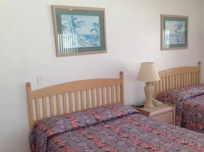 a bedroom with two beds and a lamp on a night stand at Birch Patio Motel in Fort Lauderdale